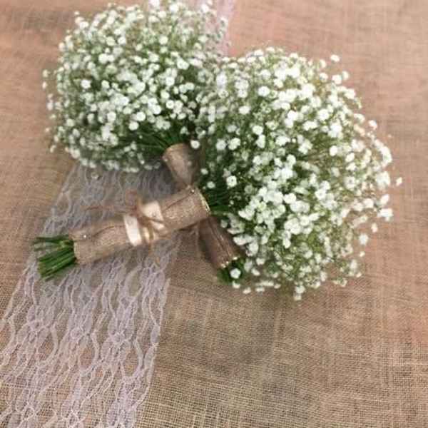 Two small white baby's breath bouquets tied with ribbon and lace