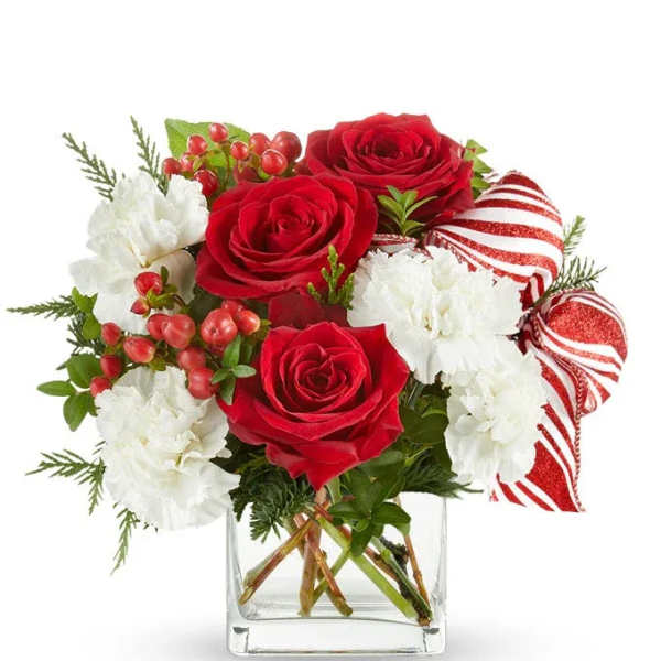 Red roses and white carnations in a clear square vase with striped ribbon accents
