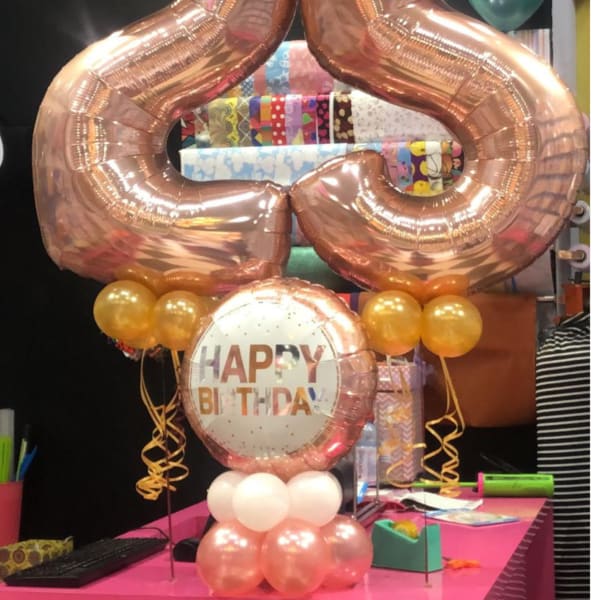 Rose-gold number 25 balloons with a Happy Birthday balloon and small gold balloons.