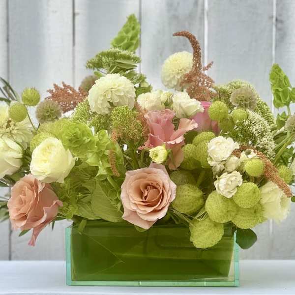 Mixed pastel bouquet in a green rectangular vase