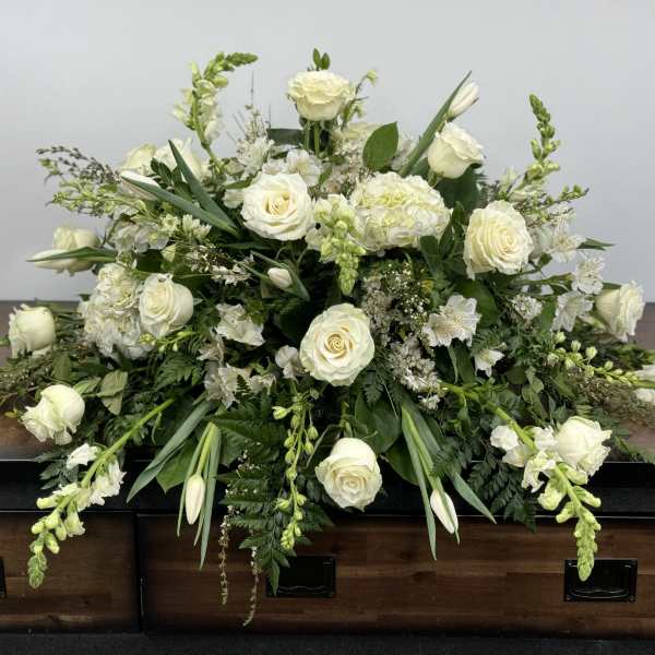 White floral casket spray with roses and lilies