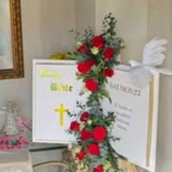 Tall arrangement of red roses with greenery in a white vase