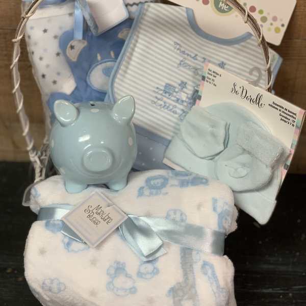 Baby gift basket with blue blankets, bibs, and a piggy bank