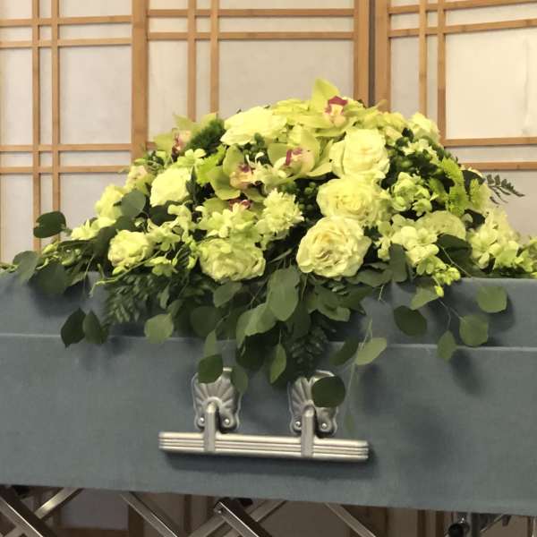 Large yellow floral arrangement on top of a casket
