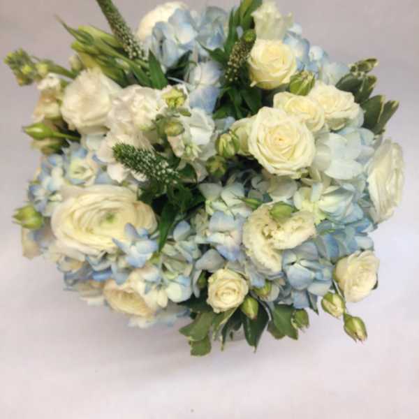 Bouquet of white roses and pale blue hydrangeas with green accents