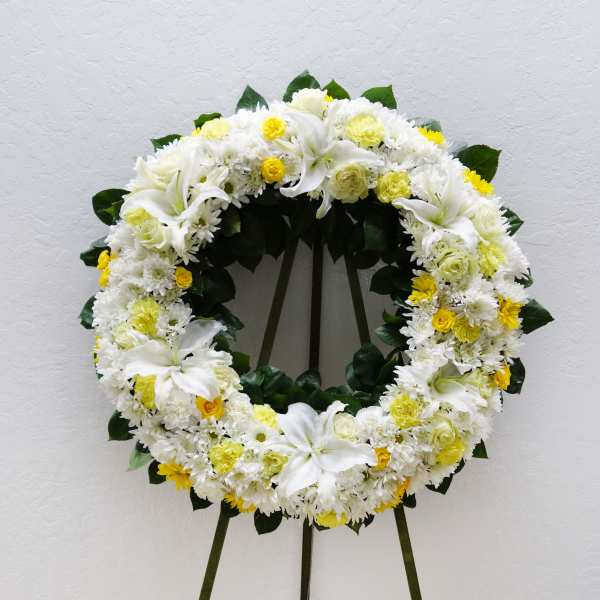 White and yellow floral wreath on a standing easel