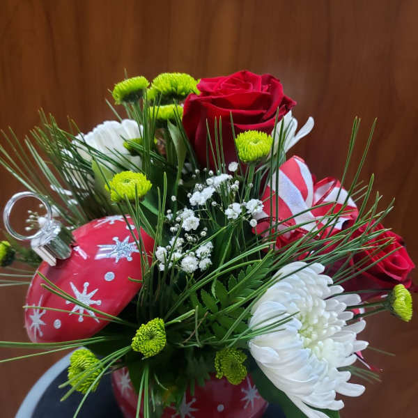 Red roses and white chrysanthemums in a red ornament-shaped vase