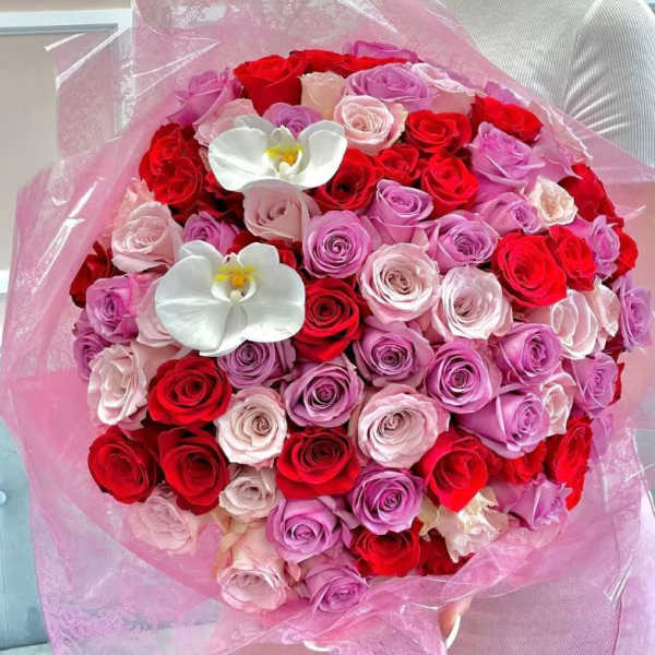 Large bouquet of red, pink, and lavender roses with white orchids