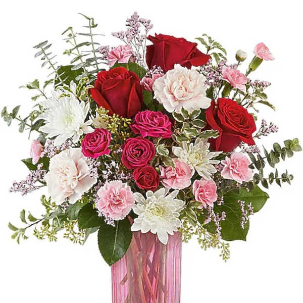 Pink and red flower bouquet in a tall pink glass vase