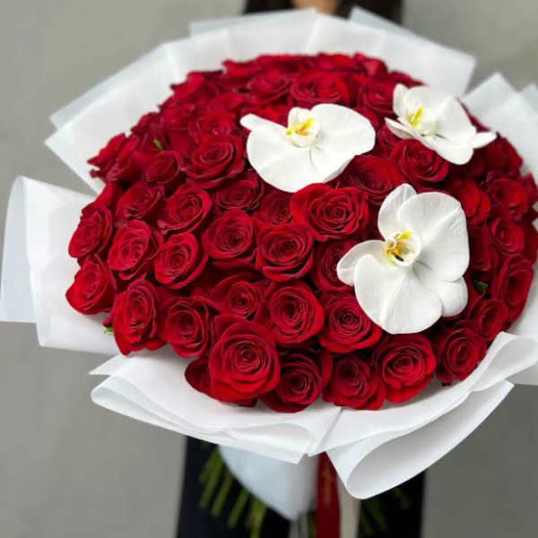 Bouquet of red roses with white orchid blooms wrapped in white paper