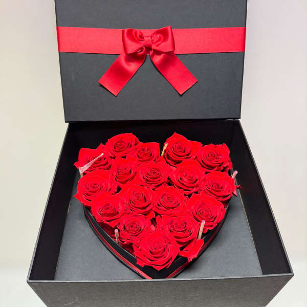 Heart-shaped box of red roses with a red ribbon bow