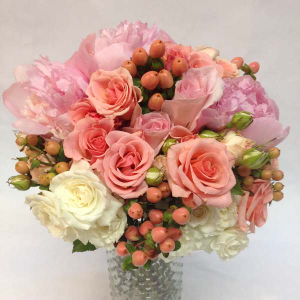 Pink and white rose bouquet in a textured glass vase