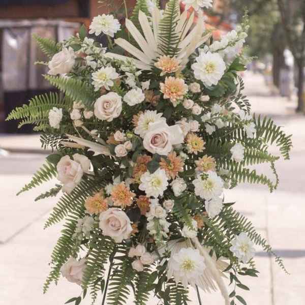 Standing floral spray with white and blush flowers on an easel