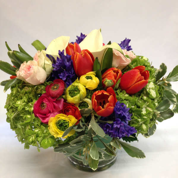 Colorful mixed flower arrangement in a clear glass vase