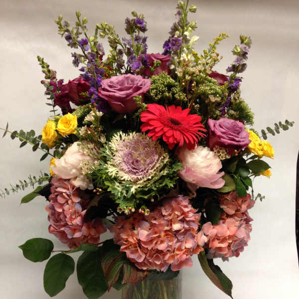 Mixed bouquet with roses, gerbera daisies, hydrangeas, and a glass vase