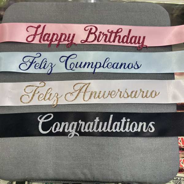 Four glittered satin ribbons with birthday and congratulations messages