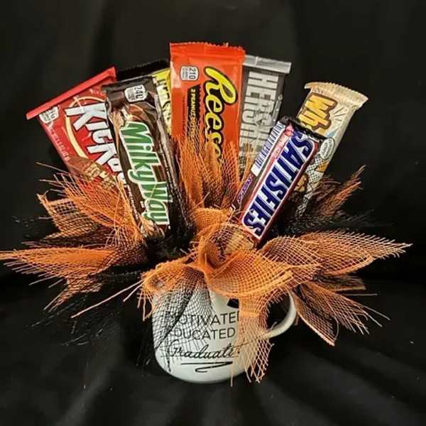 Candy bars arranged in a mug with orange mesh ribbon