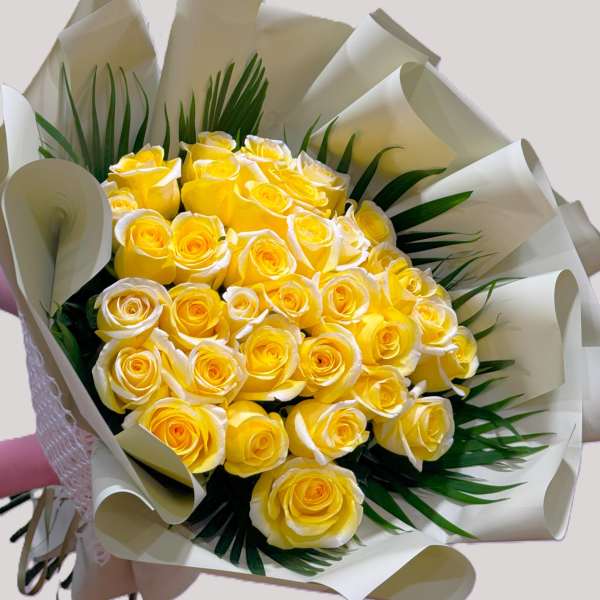 Bouquet of yellow roses wrapped in white paper