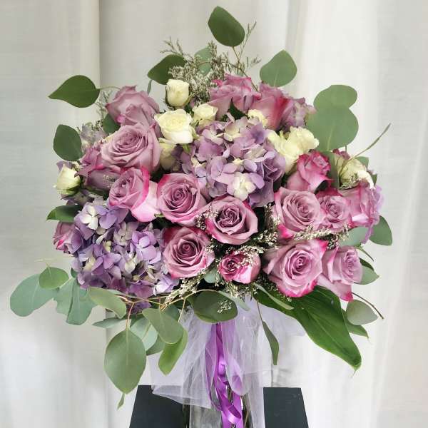 Bouquet of pink and lavender roses with hydrangeas and eucalyptus