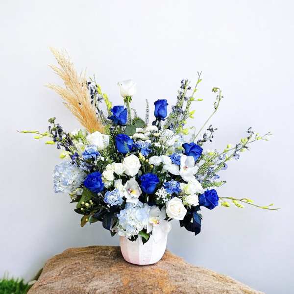 Blue and white floral arrangement in a white vase