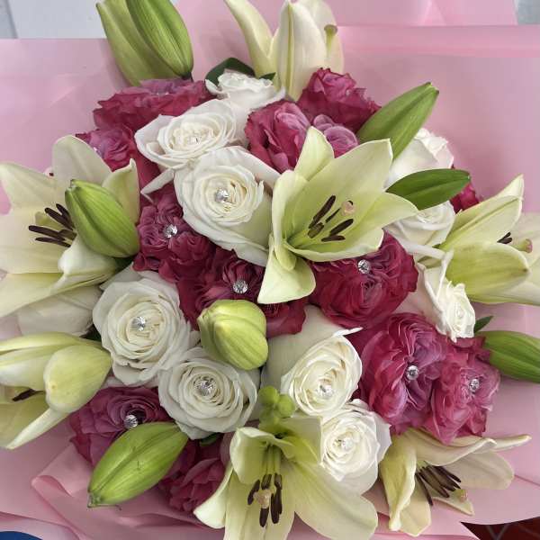 Pink and white bouquet with lilies and roses wrapped in pink paper