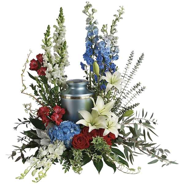 Sympathy arrangement with red roses, white lilies, blue flowers, and a blue urn