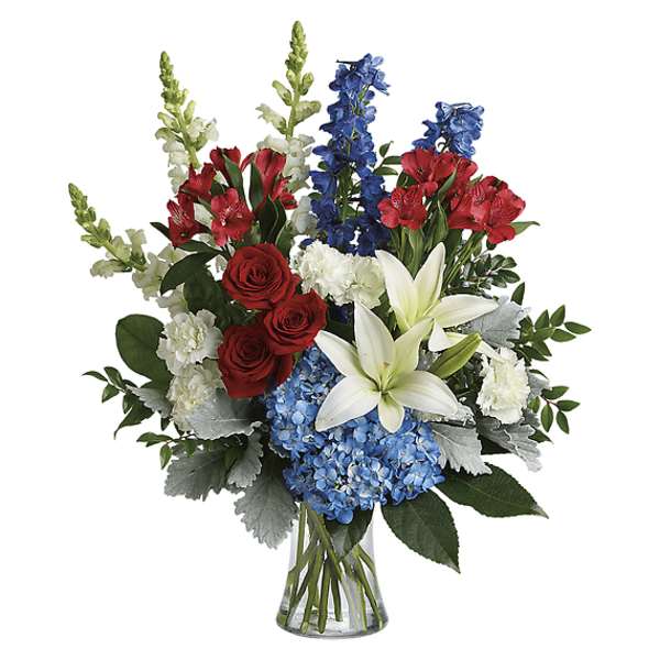 Bouquet of red, white, and blue flowers in a clear glass vase