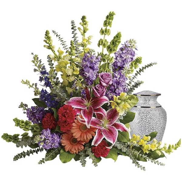 Mixed bouquet with lilies, roses, daisies, and purple blooms in a decorative urn