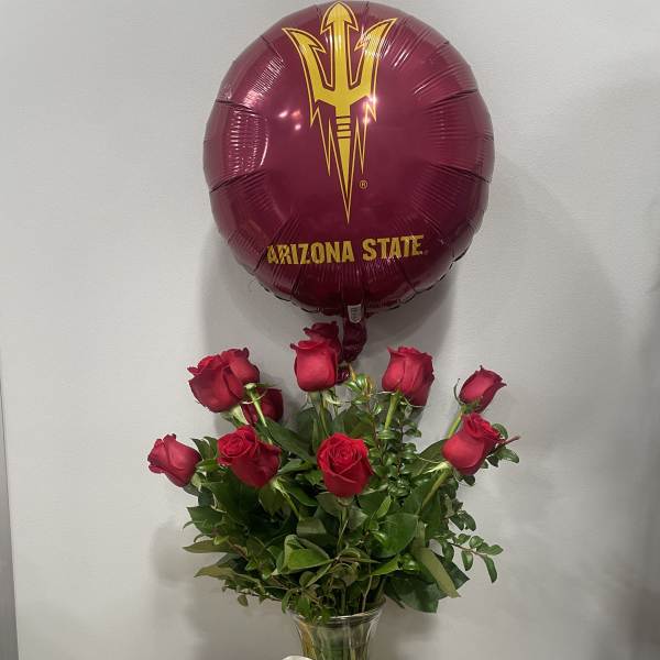 Red roses in a glass vase with an Arizona State balloon and cap