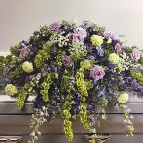 Lavender and green floral casket spray with cascading blooms