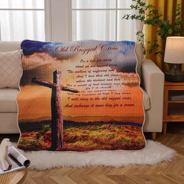 A printed blanket with a cross and religious text draped over a sofa