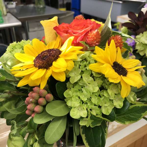 Bouquet with yellow sunflowers, a red rose, and green hydrangea
