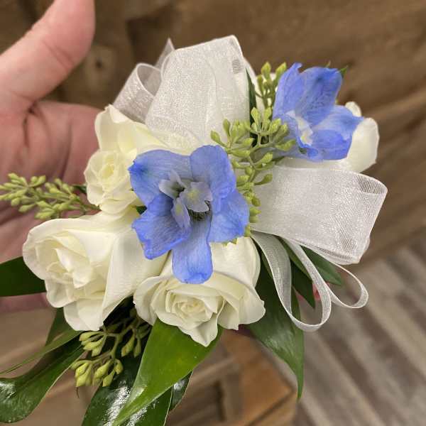 Small bouquet of white roses and blue flowers with a sheer ribbon