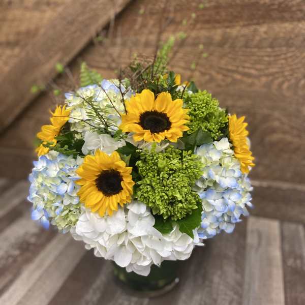 Bouquet of sunflowers and blue-white hydrangeas in a vase