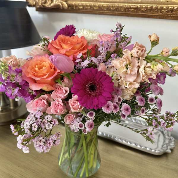 Mixed pink and orange flowers in a glass vase