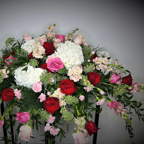 Large arrangement of red, pink, and white flowers on a stand