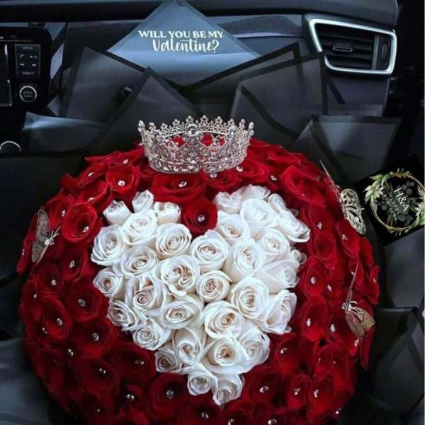 Heart-shaped bouquet of red and white roses with a crown topper