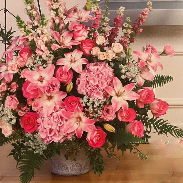 Large pink floral arrangement in a decorative vase