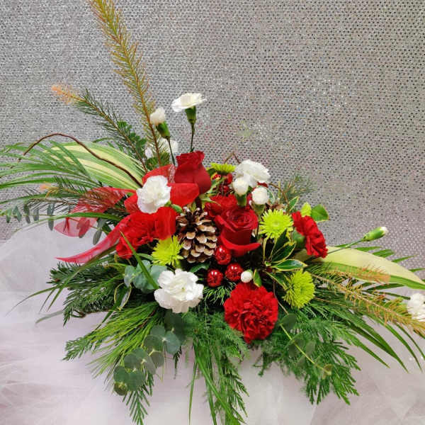 Red and white floral arrangement with pinecones and greenery