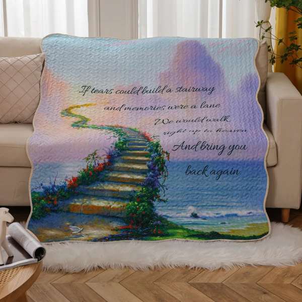 Pastel memorial blanket with a staircase scene and printed quote on a couch