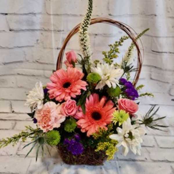 Basket arrangement with pink gerberas, roses, and white daisies