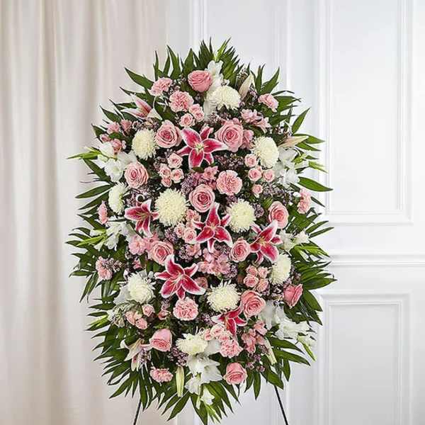 Standing funeral spray with pink roses, white lilies, and chrysanthemums