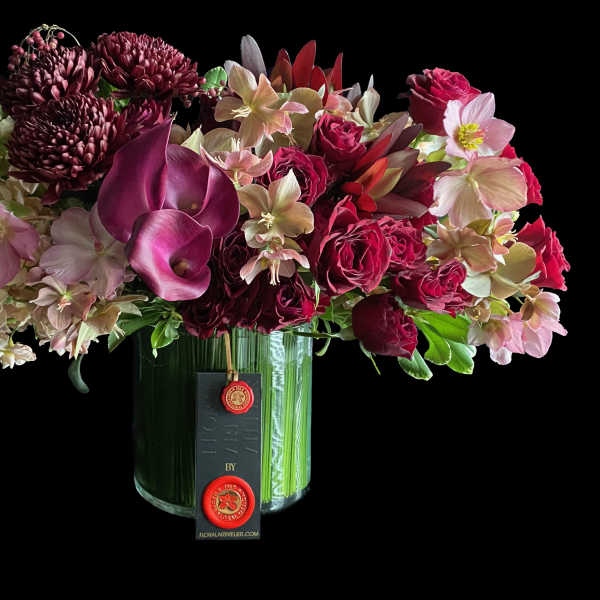 Mixed bouquet of burgundy and pink flowers in a glass vase