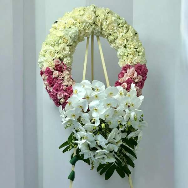 Heart-shaped floral wreath with white and pink roses and white orchids
