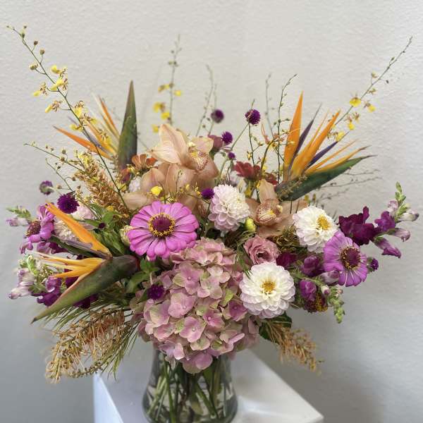 Mixed bouquet in a clear glass vase with pink, white, purple, and orange blooms