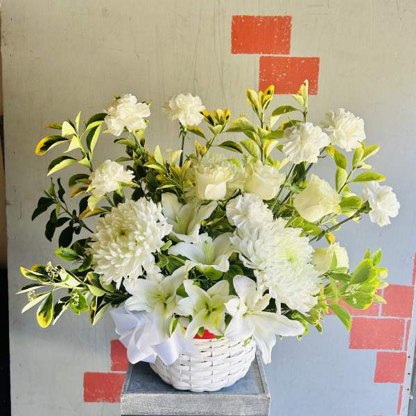 White lilies and chrysanthemums in a white basket