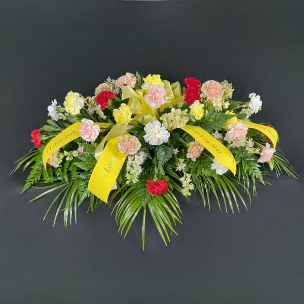 Sympathy floral spray with carnations and yellow ribbons