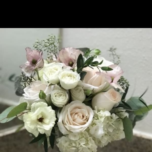 Bouquet of pale roses and white blooms in a glass vase