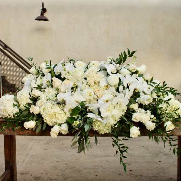 Large white floral arrangement on a wooden table