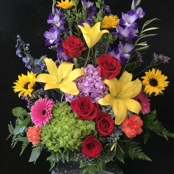 Colorful mixed flower arrangement with roses, lilies, and sunflowers